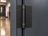Black US19 spring hinge installed on a door – hallway close-up